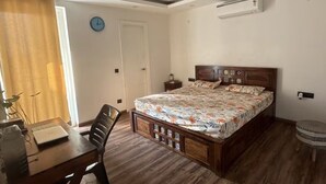 Un dormitorio con cama, escritorio y una silla.