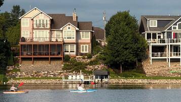 A lakeside property with a large house featuring multiple decks and a dock.