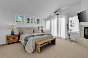 A bedroom with a bed, bedside tables, a bench, a TV, and a fireplace. - North Boulder Elegance - Newlands Neighborhood (Boulder)