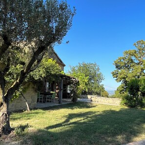 A stone house with a patio and outdoor seating area. - A beautiful, restored farmhouse in a quiet setting, with an enclosed garden for dogs and a stunning view. (Viviers)