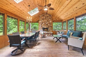 A wooden cabin interior with a stone fireplace, dining area, and seating. - Welcome to the TreeHouse, Privacy right by downtown New Buffalo (New Buffalo)