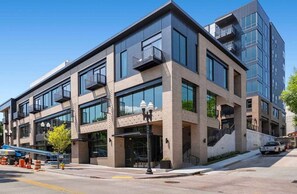 A modern multi-story building with large windows and balconies. - City Lights in South Gay | Knoxville (Knoxville)