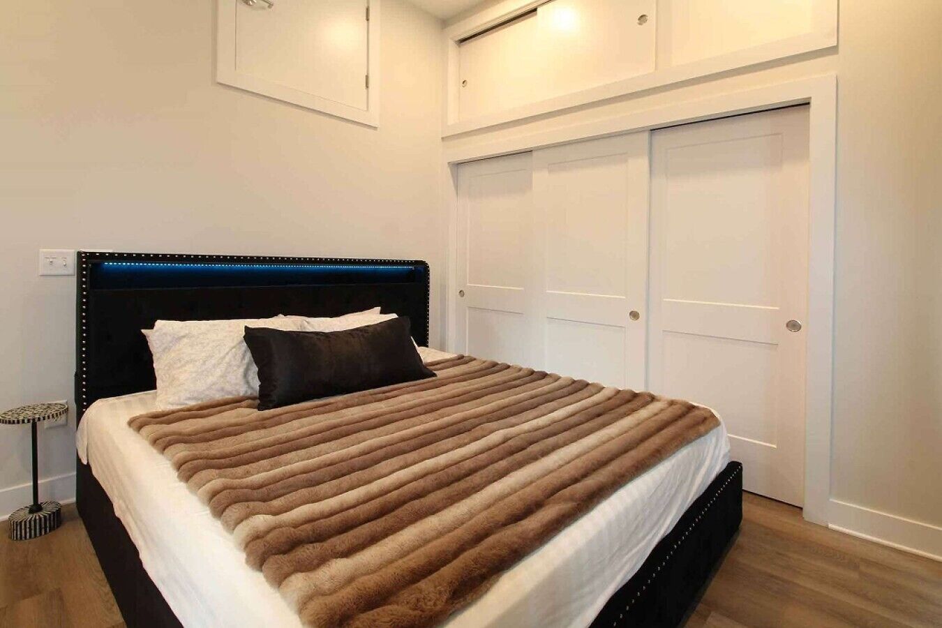 Ein Schlafzimmer mit Bett, Nachttisch und Kleiderschrank.