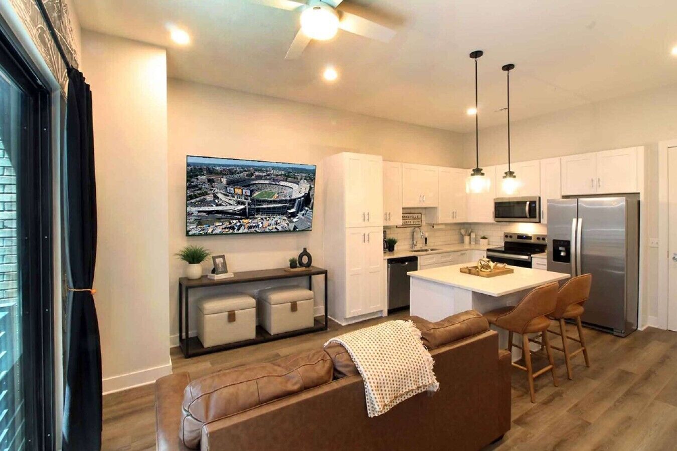 A modern kitchen with white cabinets, stainless steel appliances, and a central island.