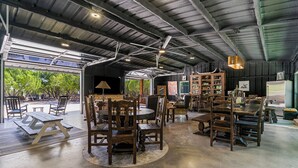 An interior with high ceilings, exposed beams, and a mix of seating arrangements including tables and chairs.