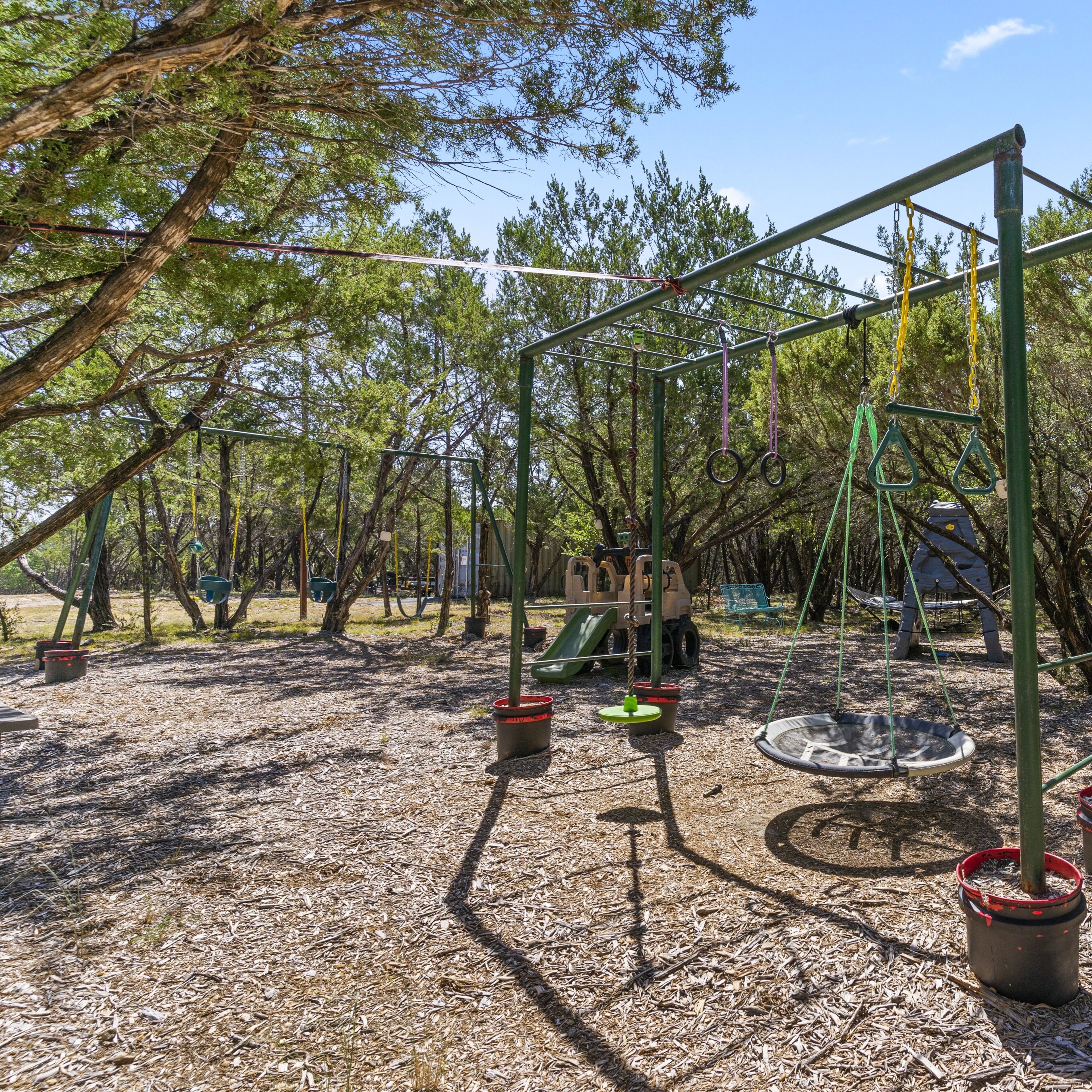 Ein Spielplatz mit Schaukeln, einer Rutsche und Klettergerüsten.