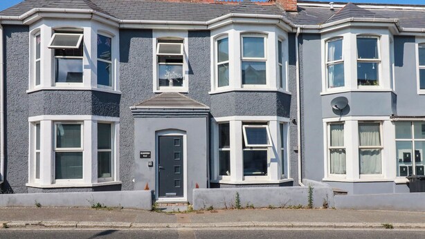 A two-story residential building with bay windows, a front door, and a satellite dish. - Higher Tower Road (Newquay)