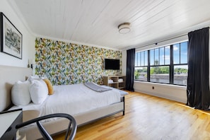 A bedroom with a bed, a desk, a chair, a TV, and a window with a view. - The Palms at 76 (Miami Beach)