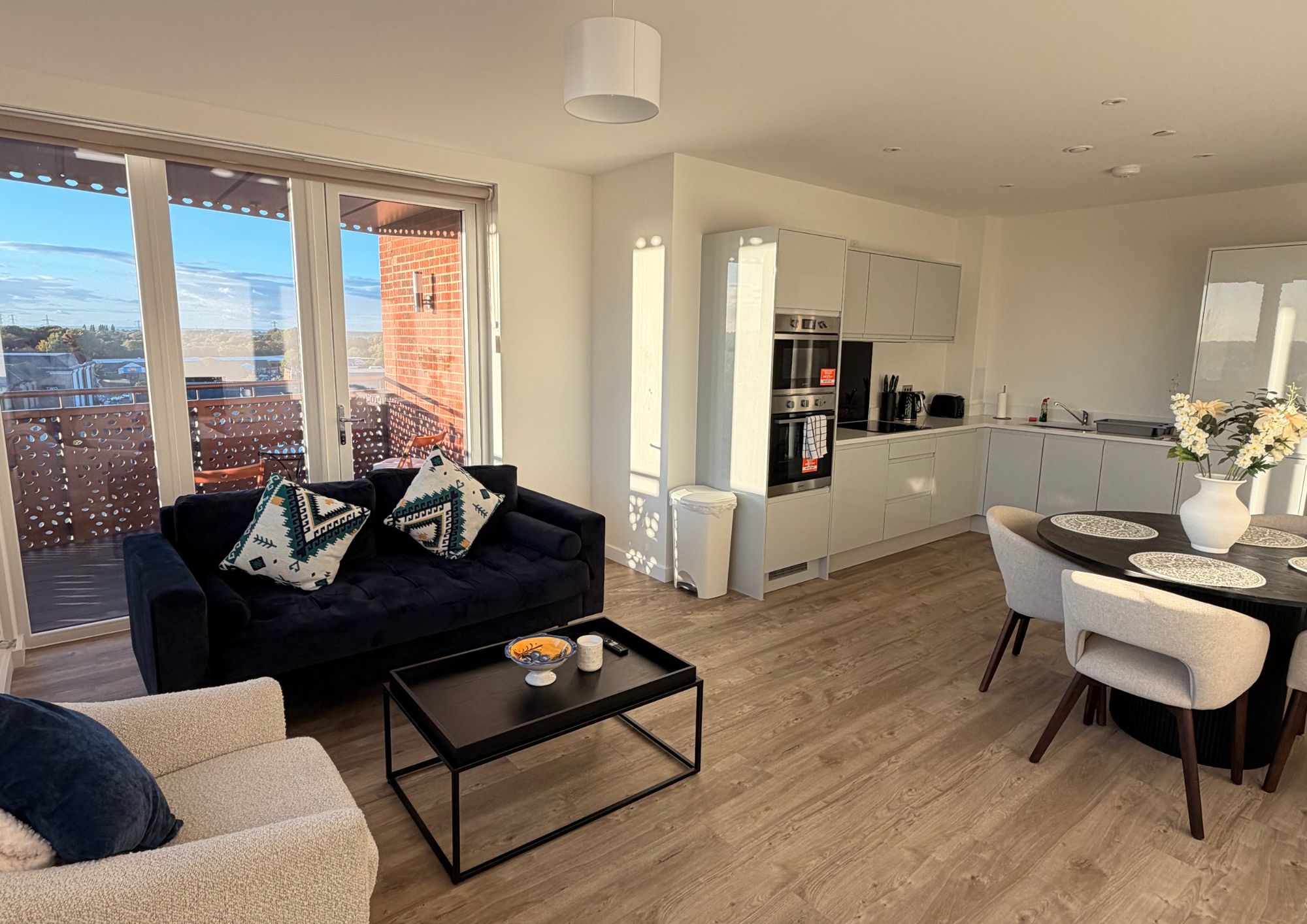 Un salon moderne comprenant un canapé, une table basse et un coin repas avec des chaises et une table.