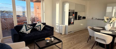 Una sala de estar moderna con un sofá, una mesa de centro y un comedor con sillas y una mesa.