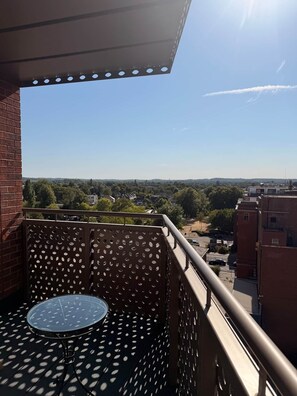 Ein Balkon mit rundem Tisch und Blick auf die Stadtlandschaft.