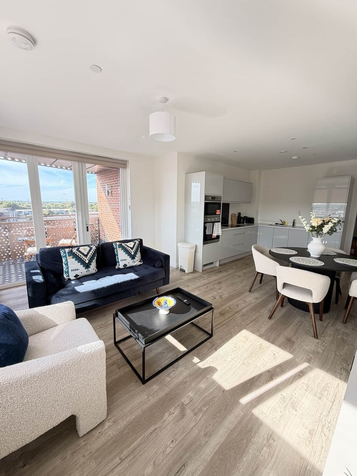 A modern living space with a sofa, coffee table, and dining area.
