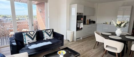 A modern living space with a sofa, coffee table, and dining area.