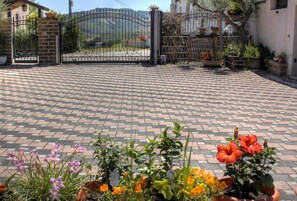 A paved courtyard with a gated entrance, potted plants, and a view of the surrounding landscape. - Abruzzo Hills Villa – Near the Sea, Villages & Mountains (Treciminiere)