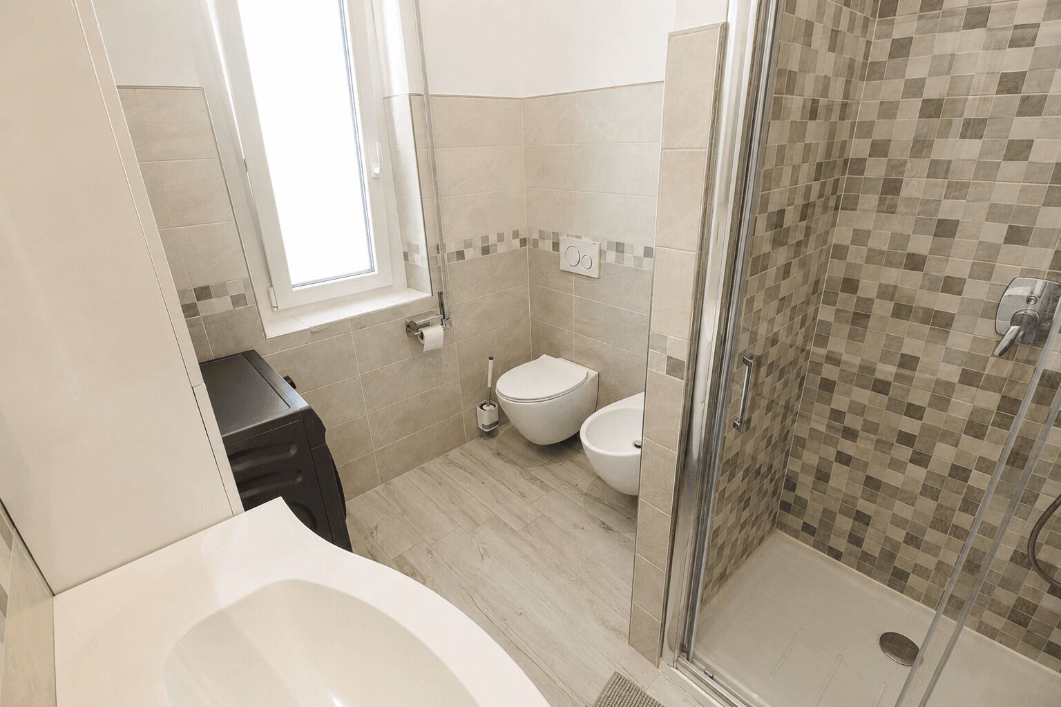 A bathroom with a shower, toilet, and sink.