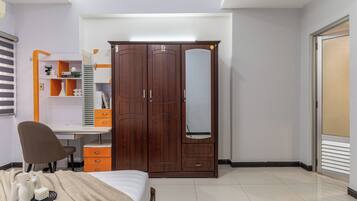 A bedroom with a bed, a desk, a wardrobe, and a chair.