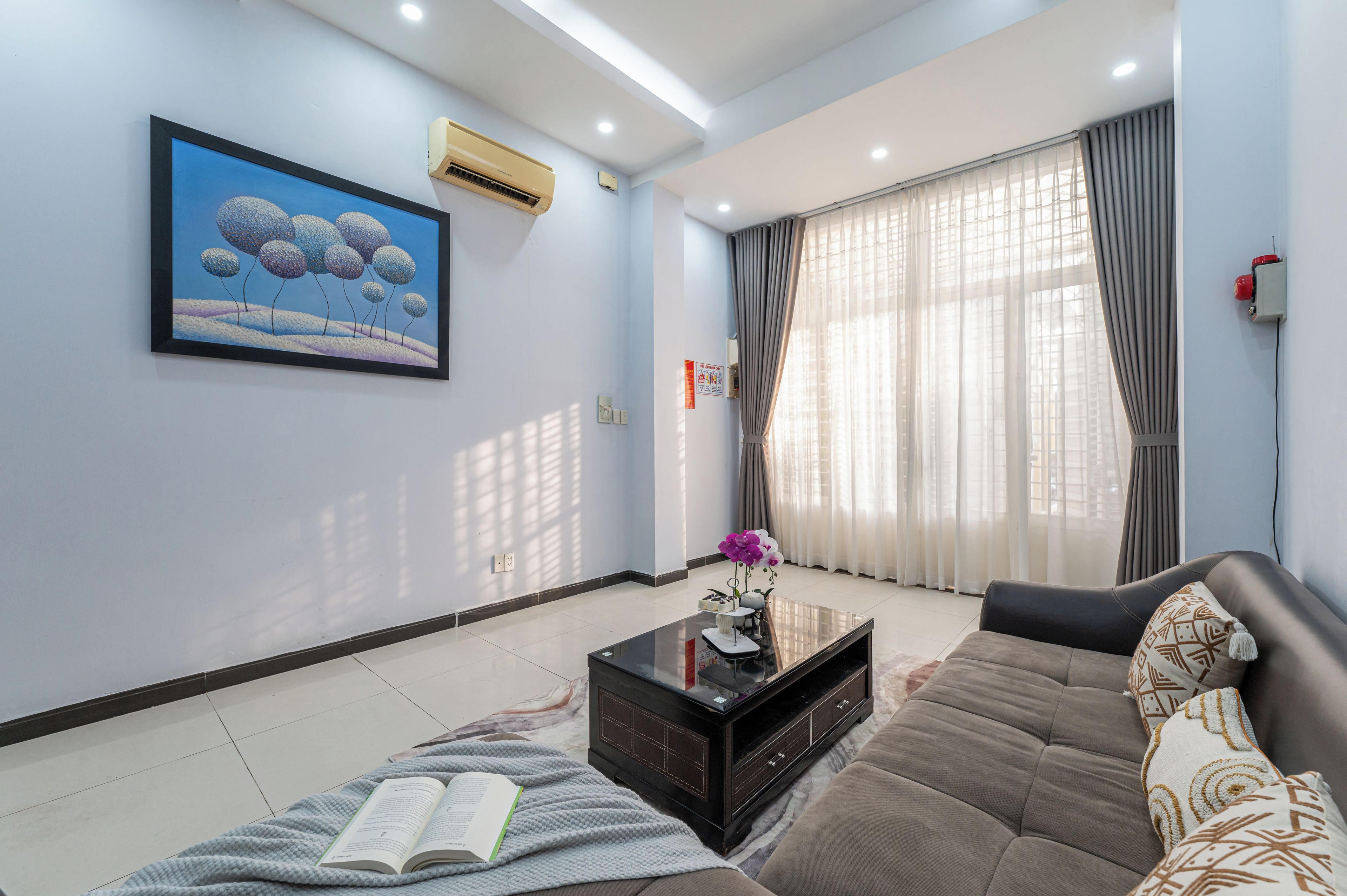 A modern living room with a sofa, a coffee table, and a painting on the wall.