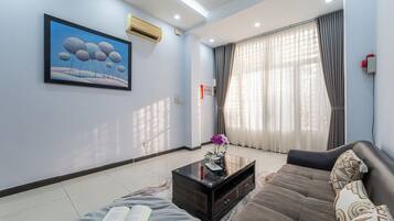 A modern living room with a sofa, a coffee table, and a painting on the wall.