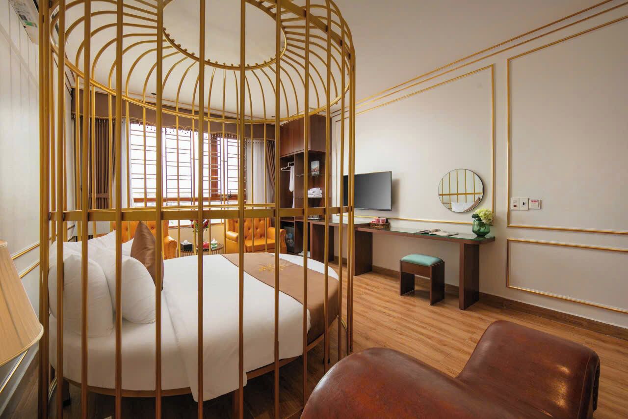 A hotel room with a bed, a desk, a chair, a television, and a wardrobe.