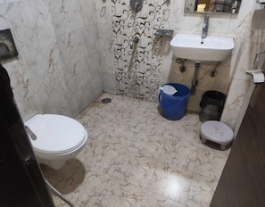 A bathroom with a toilet, sink, and shower.
