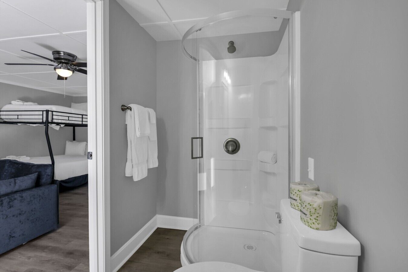 A compact room with a bunk bed, a shower stall, and a toilet.