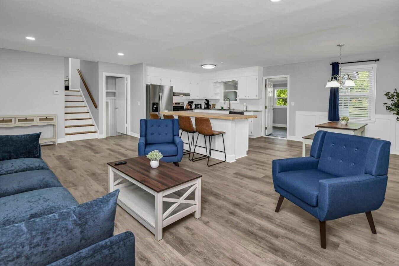 A modern living room with a sofa, a coffee table, and a blue armchair.
