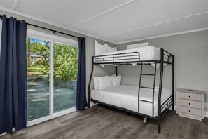 Ein Schlafraum mit Etagenbetten und einer Schiebetür zu einem Balkon.