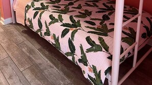 A bunk bed with a leaf-patterned bedspread and a ladder on the left side. - 124 Seashell Cove Poinciana Place (Miramar Beach)