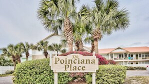 Schild für '320 Poinciana Place' mit einem Gebäude im Hintergrund.