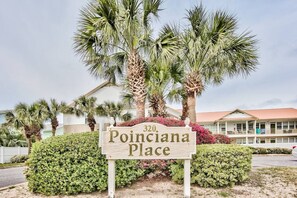 Un letrero indica '320 Poinciana Place', con un edificio al fondo.