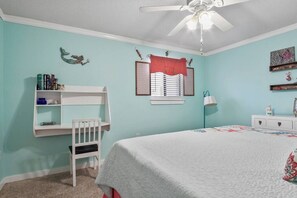 A bedroom with a bunk bed, a desk, a window with blinds, a ceiling fan, and a bed with a floral bedspread. - 103 Siren Cove Misty Cove (Destin)
