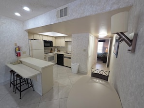 A compact kitchen with a central island, a microwave, stove, and dishwasher. - 1BR Villa Near Disney Pool & Resort Amenities (Kissimmee)