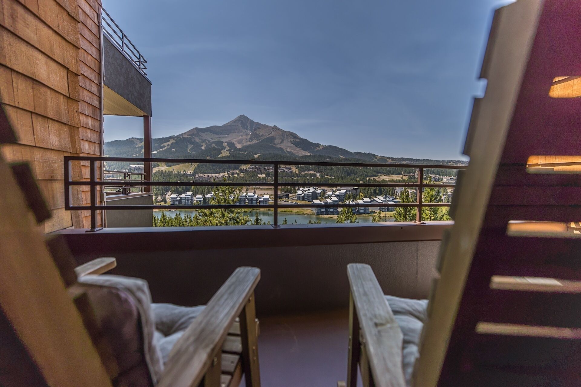 Een balkon met uitzicht op een berg en een meer.