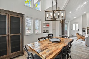 A spacious kitchen with a wooden dining table, modern light fixtures, and large windows. - Walk to Main Street and Lift | Fireplace (Park City)