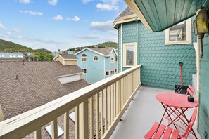 A balcony with a view of neighboring houses, a small table with chairs, and a lantern. - Walk to Main Street and Lift | Fireplace (Park City)