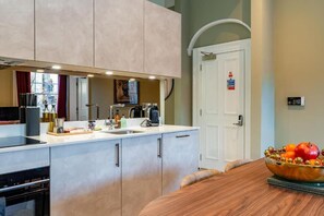 Eine moderne Küche mit Backofen, Kaffeemaschine und Spüle.