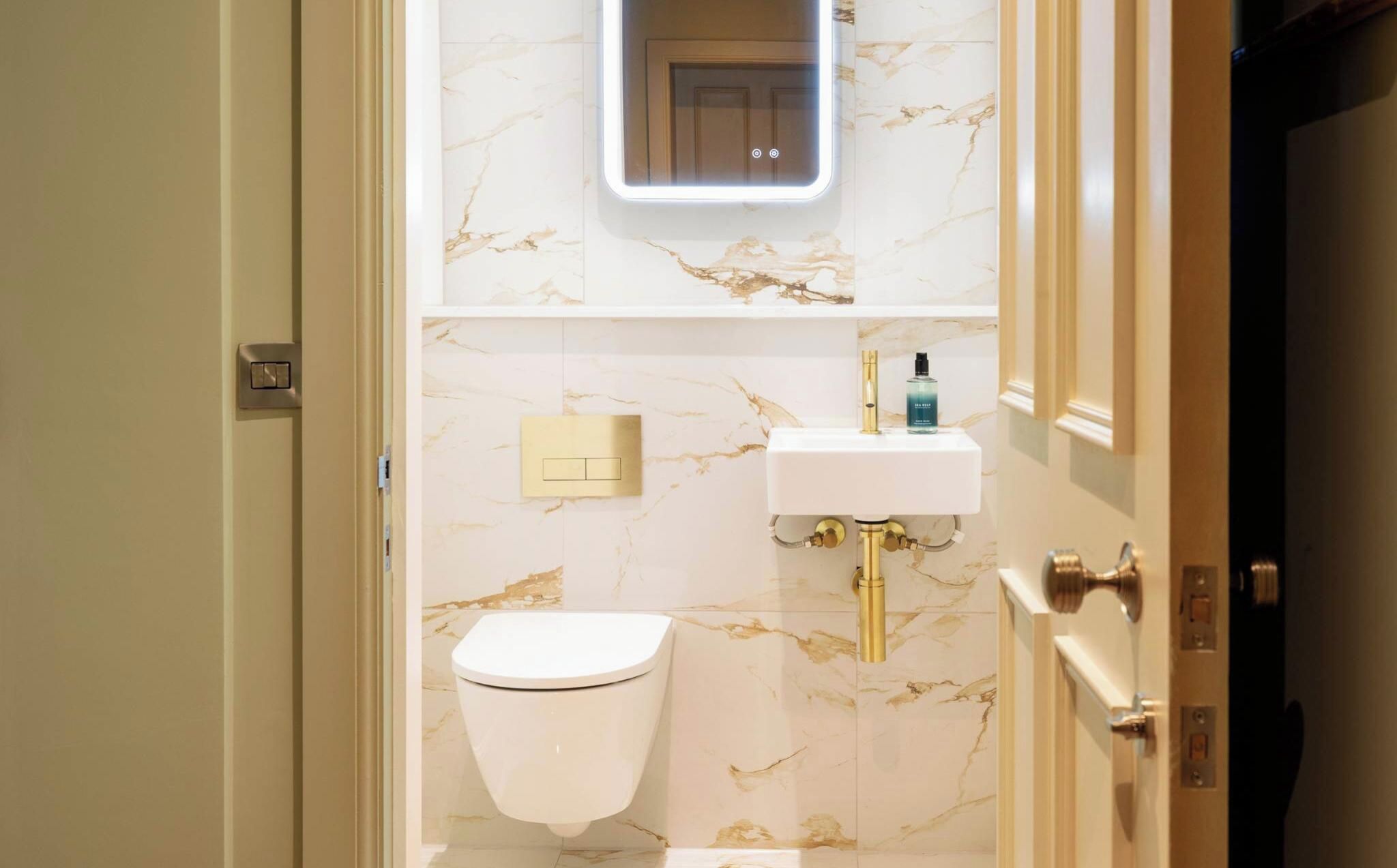Ein Badezimmer mit Toilette, Waschbecken und Spiegel.