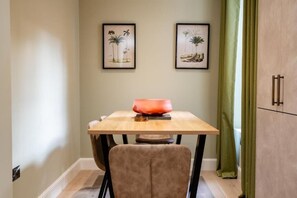 A dining area with a table, chairs, and framed artwork on the wall. - Pentland Suite - 1 bedroom accessible apartment at Hill Street (Edinburgh)