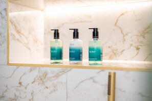 A marble wall with three bottles of Sea Kelp shampoo and conditioner on a shelf. - Pentland Suite - 1 bedroom accessible apartment at Hill Street (Edinburgh)