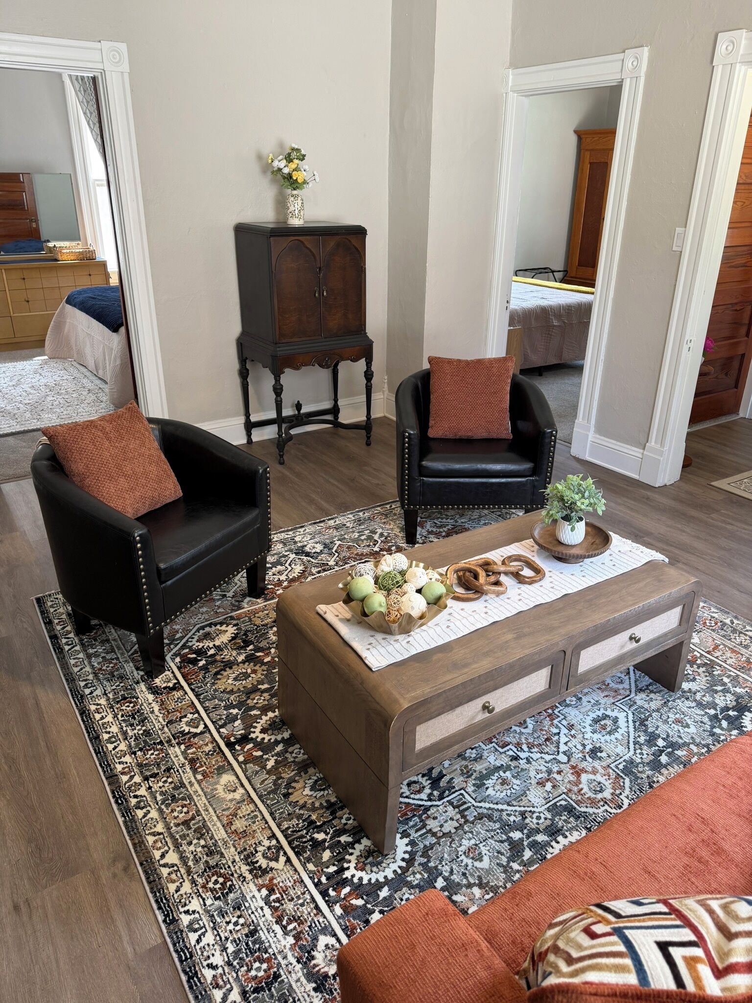 Un salon comprenant un canapé, un fauteuil, une table basse et un meuble.