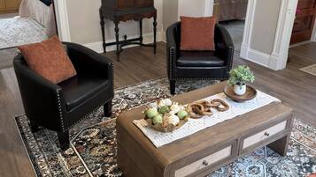 Un salon comprenant un canapé, un fauteuil, une table basse et un meuble.
