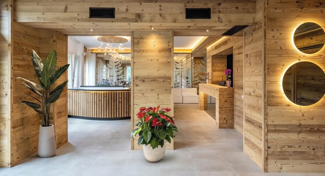 A reception area with wooden paneling, a reception desk, and a potted plant.