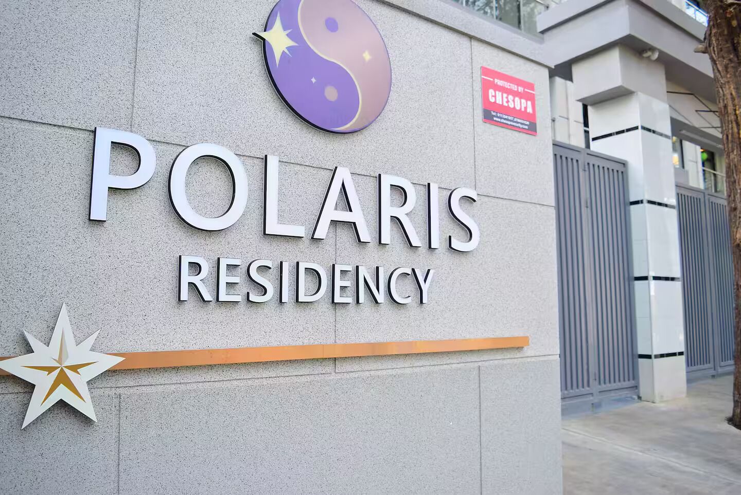 Skilt med 'POLARIS RESIDENCY', en stjerne og et yin-yang symbol.