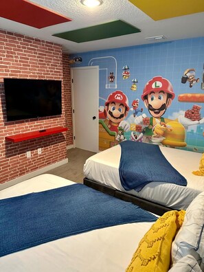 A bedroom with a TV mounted on a brick wall, a bed with a blue striped pillow, and a mural of Mario and Luigi characters. - Magical Family Escape! Spacious 3BR Home Minutes from Disney! (Kissimmee)