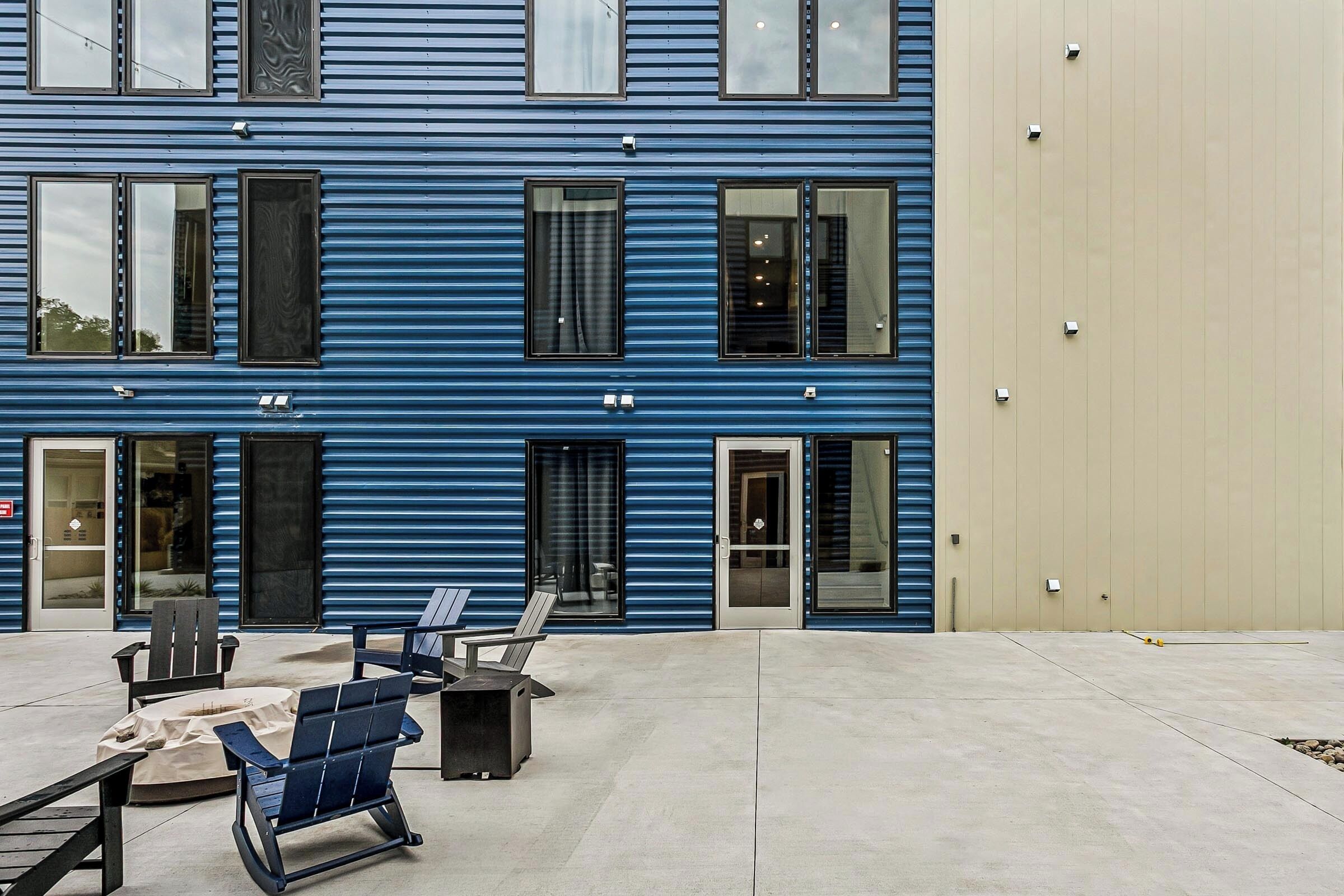 Un edificio de varios pisos con fachada azul, ventanas amplias y techo plano.
