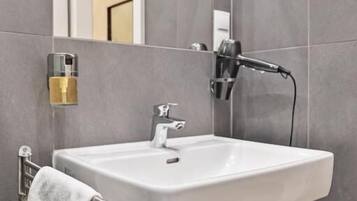 A bathroom with a white sink, a towel rack, and a mirror.