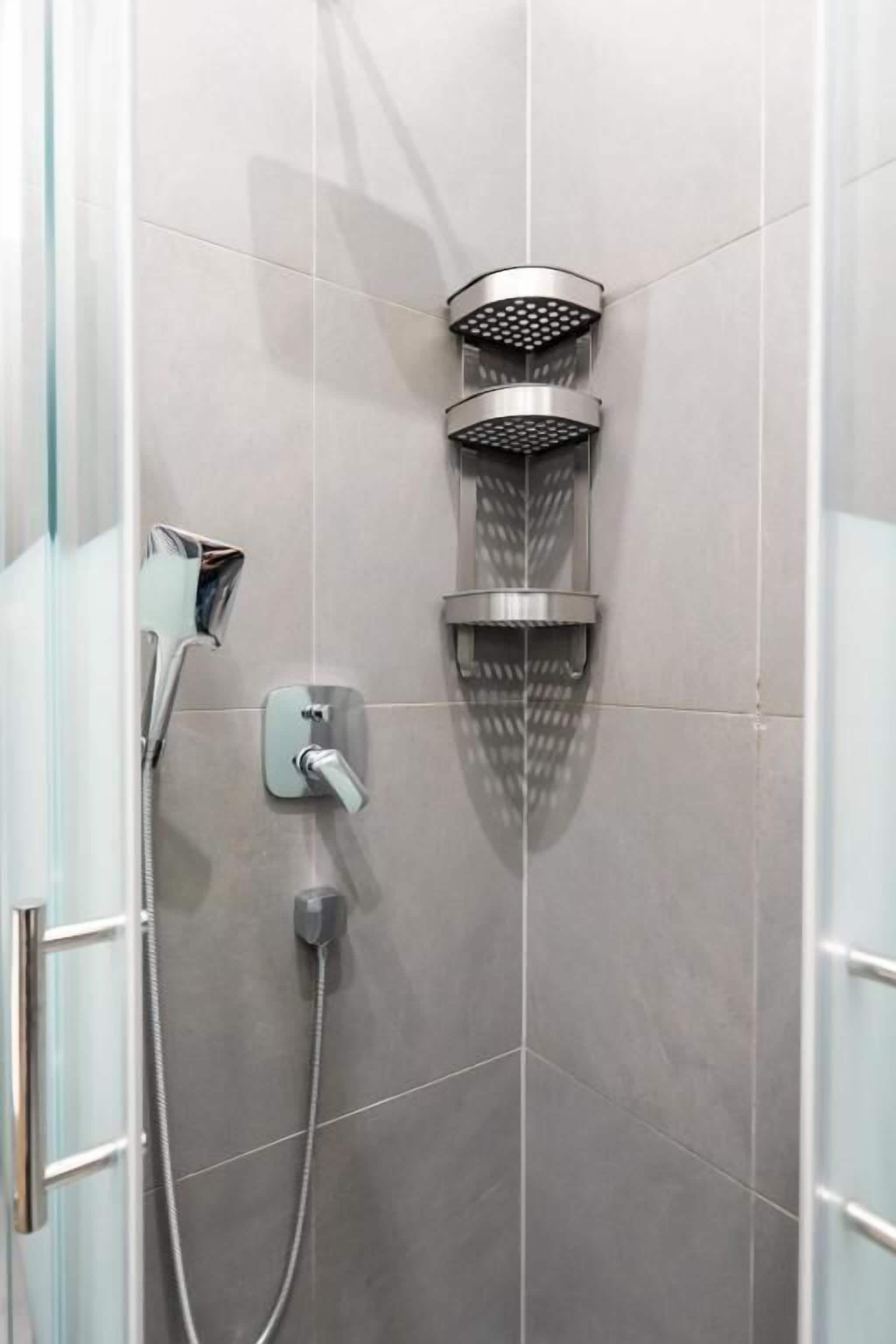 Eine Dusche mit Handbrause und fest installierter Duschköpfe.