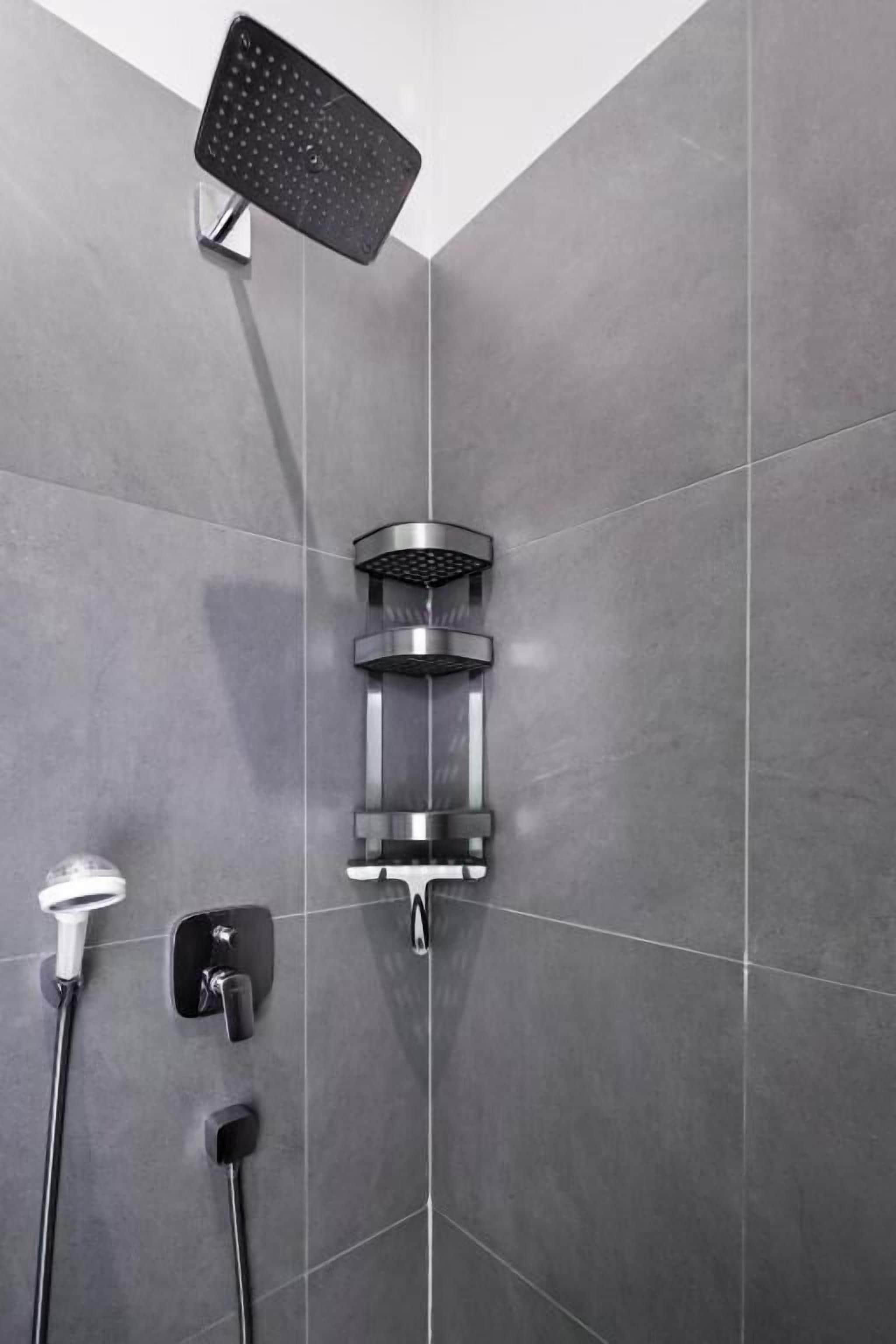 A modern shower with a handheld showerhead, a fixed showerhead, and a wall-mounted control panel.