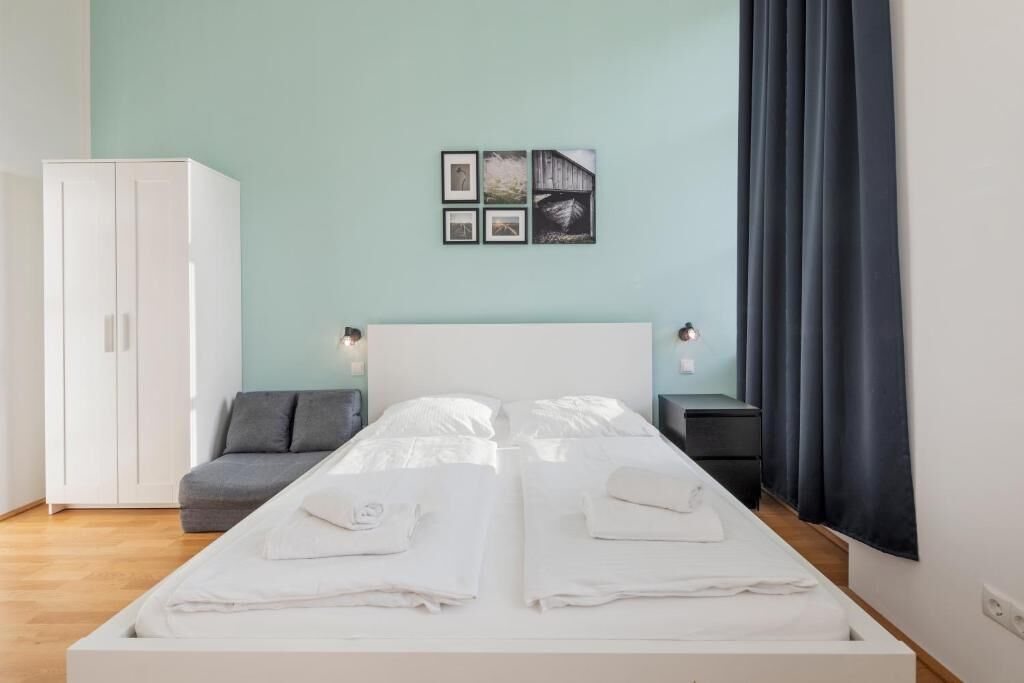 Une chambre à coucher comprenant un lit, une armoire, une table de chevet et un tableau accroché au mur.