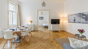 A modern living room with a dining area, a television, and artwork on the wall. - Cityswap- Wien Naschmarkt (Wien)